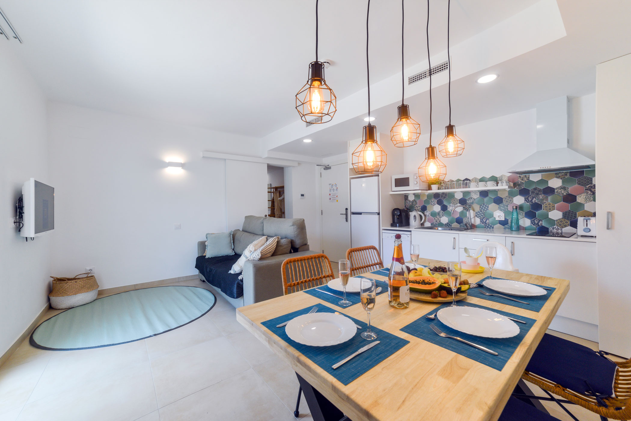 Cocina, comedor y sofá del apartamento. Bamblue Apartments - Stay Longer.